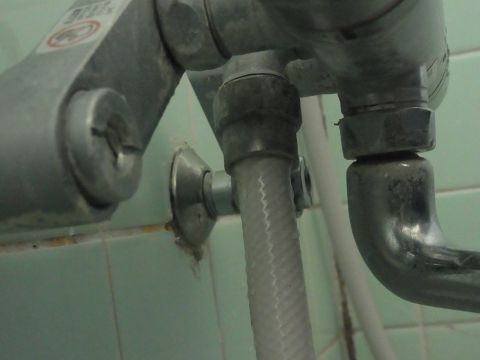 シャワー混合水栓金具のシャワーホースがつながっている付け根をウォーターポンププライヤーやレンチを使って外します。